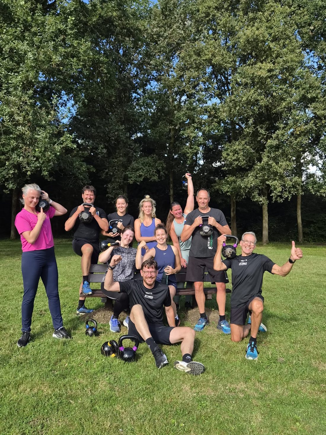 Bootcamp-groep van CrossFit Gorinchem met kettlebells op het gras in het Lingebos